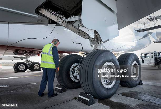 engineer inspecting a380 aircraft at stand in airport - landing gear stock-fotos und bilder