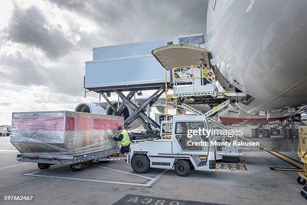 ground crew loading freight into a380 aircraft - cargo pants stock-fotos und bilder