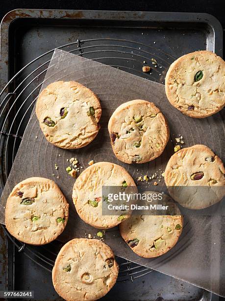 overhead view of crunchy pistachio and almond cookies on baking tray - almond cookies stock pictures, royalty-free photos & images