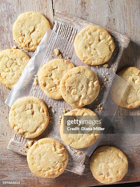 overhead view of white chocolate chunk cookies on wood - weiße schokolade stock-fotos und bilder