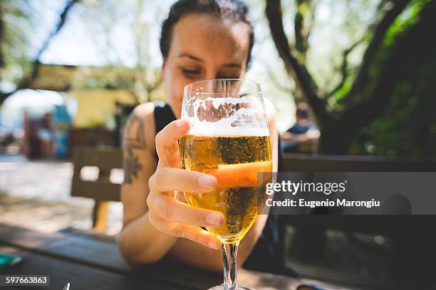 woman holding up glass of beer, garda, italy - italy beer stock pictures, royalty-free photos & images