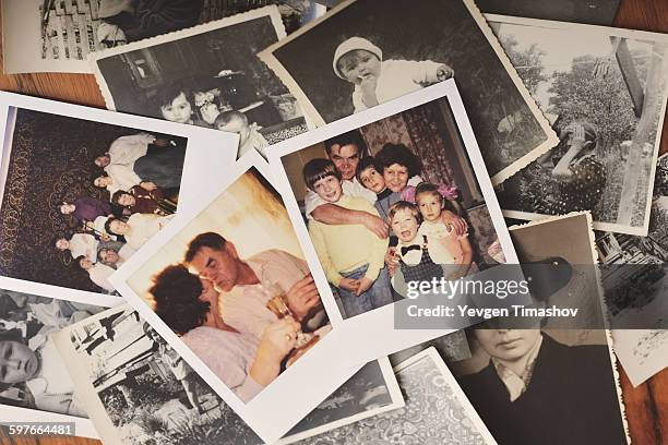 pile of family photographs on table, overhead view - souvenir de vacances photos et images de collection