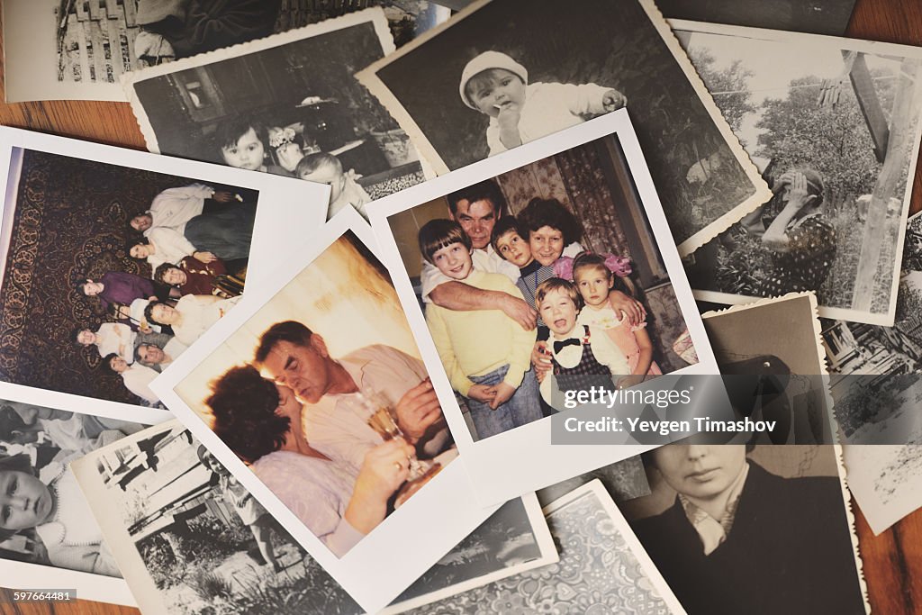 Pile of family photographs on table, overhead view