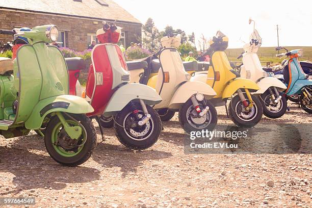 colourful scooters parked in a row - vespa stock pictures, royalty-free photos & images