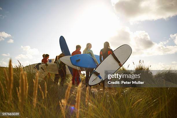 group of surfers standing on beach, holding surfboards, rear view - cornwall england stock-fotos und bilder