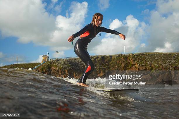 young female surfer riding wave - bud fotografías e imágenes de stock