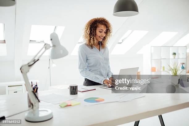 latina mujer de negocios trabajando en su oficina. - desk lamp fotografías e imágenes de stock