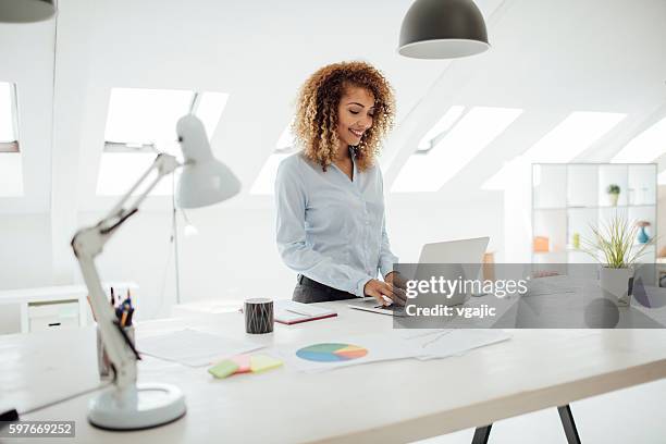 latina femme d'affaires travaillant dans son bureau. - smart windows photos et images de collection