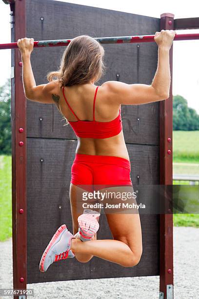 attractive young female bodybuilder practicing outdoor on horizontal bar - josef mohyla stock pictures, royalty-free photos & images