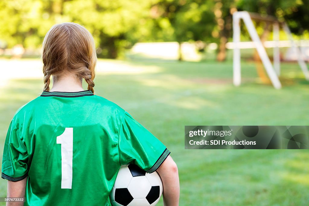 Rear view of reflective soccer player thinking about the game