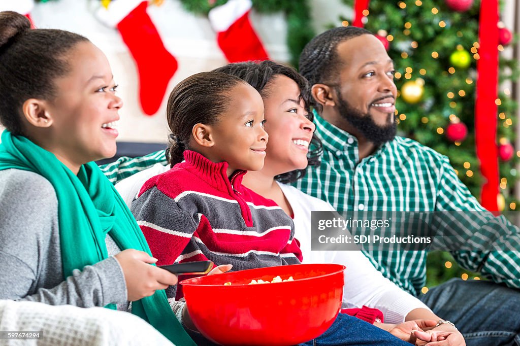 Family laughs while watching Christmas movie