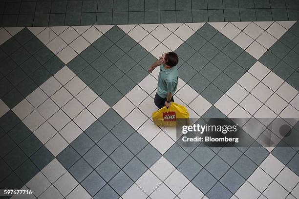 Pedestrian walks with a Lego A/S bag at the Easton Town Center shopping mall in Columbus, Ohio, U.S., on Tuesday, Aug. 23, 2016. The Conference Board...