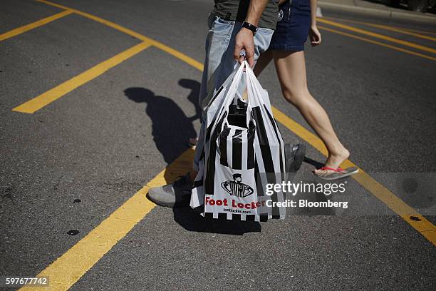 Pedestrian carries a Foot Locker Inc. Bag at the Easton Town Center shopping mall in Columbus, Ohio, U.S., on Tuesday, Aug. 23, 2016. The Conference...