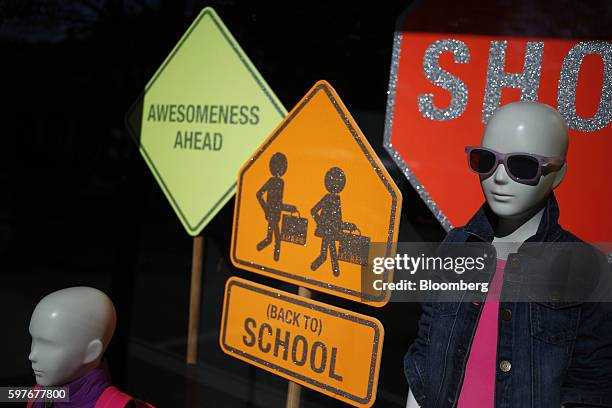 Mannequins wearing back to school clothes stand on display inside a J.Crew Group Inc. Store window at the Easton Town Center shopping mall in...