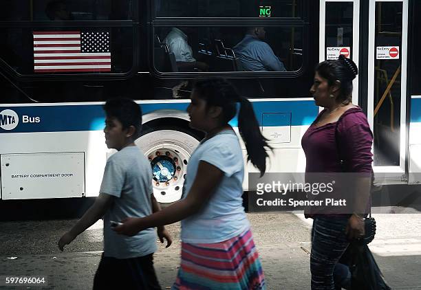 People walk in an ethnically diverse neighborhood in Queens on August 29, 2016 in New York City. Queens County is one of the five most diverse...