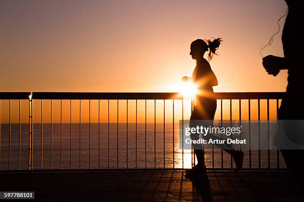 females running on barcelona boardwalk on sunrise. - runner sunrise stock pictures, royalty-free photos & images