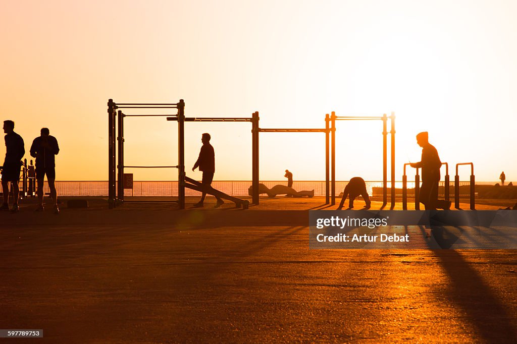 Men workout on open gym in Barcelona with sunrise