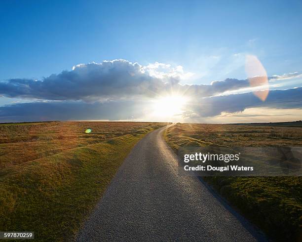 sunset at end of long country road. - single track foto e immagini stock