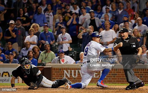 Home plate umpire Tripp Gibson calls Javier Baez of the Chicago Cubs out after being tagged by Francisco Cervelli of the Pittsburgh Pirates for the...