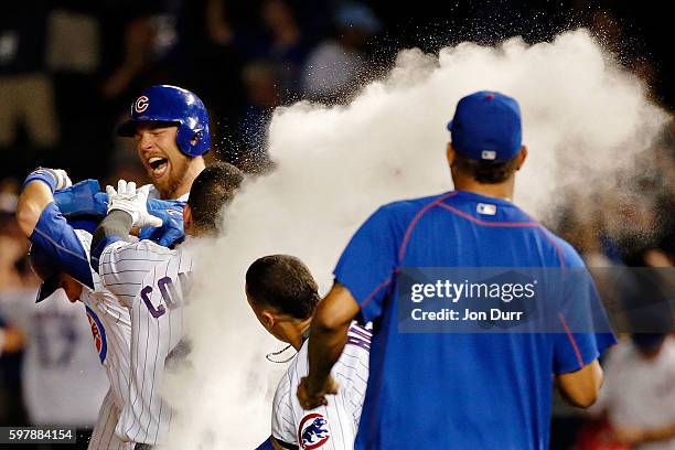 Miguel Montero of the Chicago Cubs celebrates with Ben Zobrist and Willson Contreras after hitting a walkoff RBI single against the Pittsburgh...