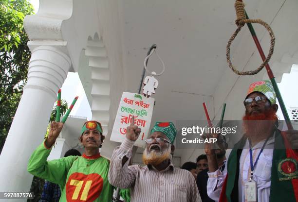 Bangladeshi activists who fought in the 1971 war shout slogans as they celebrate outside The Supreme Court in Dhaka on August 30 after Mir Quasem Ali...