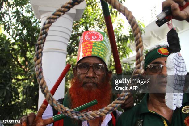 Bangladeshi activists who fought in the 1971 war shout slogans as they celebrate outside The Supreme Court in Dhaka on August 30 after Mir Quasem Ali...