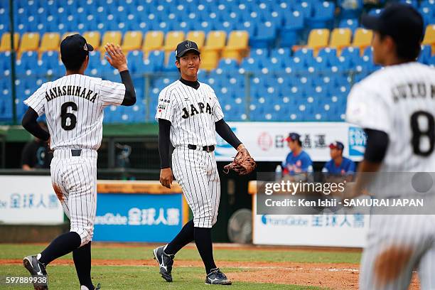 Takaaki Shima of Japan is celebrated by his teammates after the top half of the seventh inning in the game between Japan and Hong Kong during the...