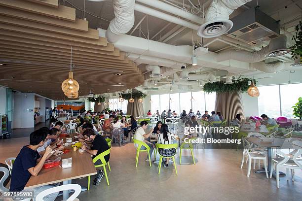 Employees sit during their lunch break in the pantry at the Garena Interactive Holding Ltd. Headquarters in Singapore, on Thursday, Aug. 25, 2016....