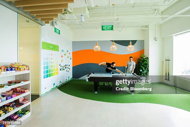 Employees play pool during their lunch break in the pantry at the Garena Interactive Holding Ltd. Headquarters in Singapore, on Thursday, Aug. 25,...