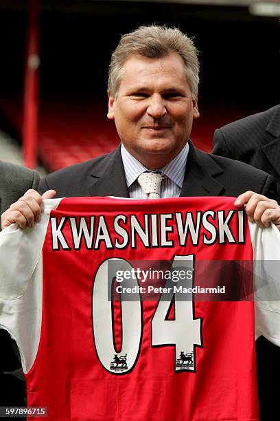 Poland's President Aleksander Kwasniewski holds up an Arsenal football shirt with his name on during a visit to Arsenal's stadium in London, May 6,...