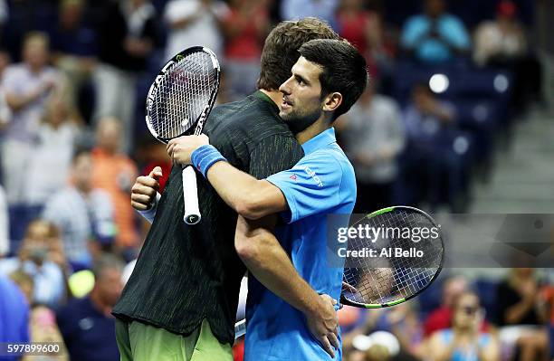 Novak Djokovic of Serbia & Montenegro embraces Jerzy Janowicz of Poland after defeating him during his first round Men's Singles match on Day One of...