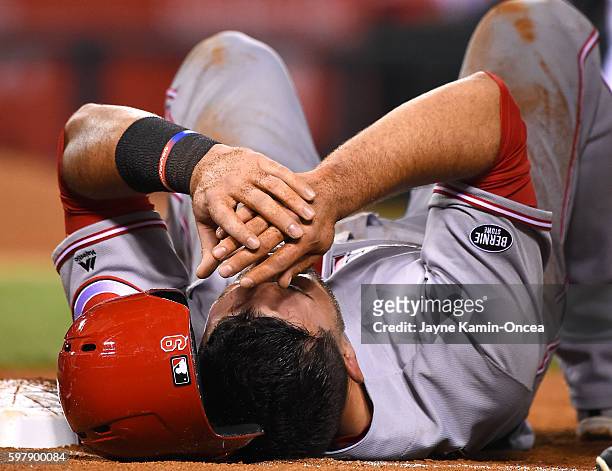 Jose Peraza of the Cincinnati Reds lays on the ground after getting hit on the head from a pick off play by Matt Shoemaker of the Los Angeles Angels...