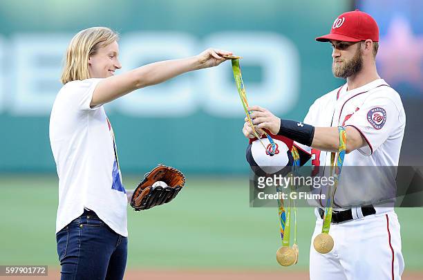 Katie Ledecky hands her Olympic medals to Bryce Harper before throwing out the opening pitch before the game between the Baltimore Orioles and the...