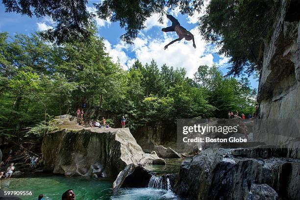 Aiden Chmura of Stowe, does a dive from the top of the ledge of formerly secret swimming hole at Warren Falls, made up of a series of small,...