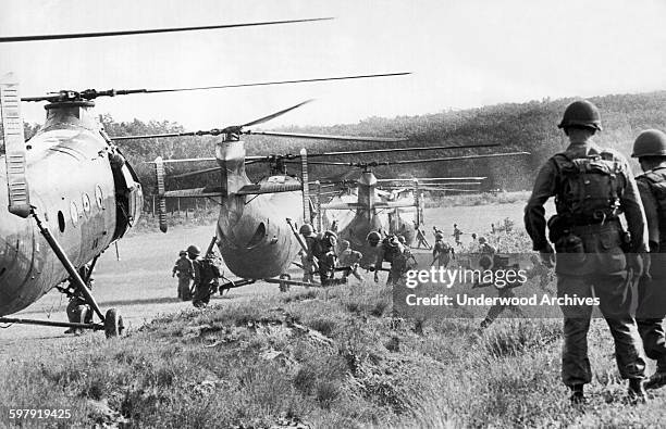 American advisors watch as Vietnamese troops run to board helicopters for an airborne anti Viet Cong operation in the jungles near Saigon, Vietnam,...