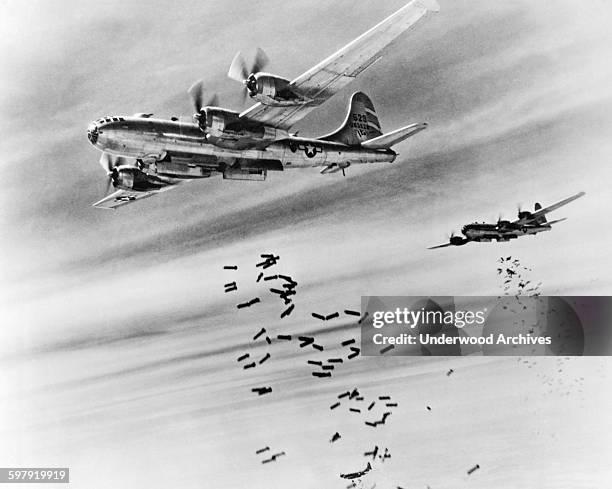 Bombs cascade from the bomb bay doors of B-29 Superfortresses during a raid on the Japanese supply depots near the Mingaladon Air Field, Burma,...