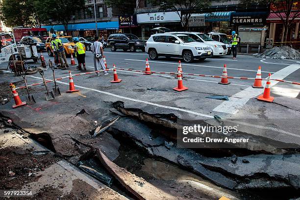 Traffic passes by a sinkhole caused by a water main break on Amsterdam Avenue, in the Upper West Side section of Manhatten, August 30, 2016 in New...