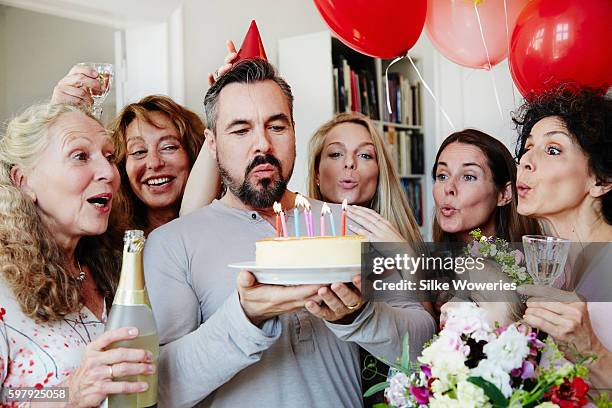 birthday boy blow out candles while good friends helping him - 40 49 años fotografías e imágenes de stock