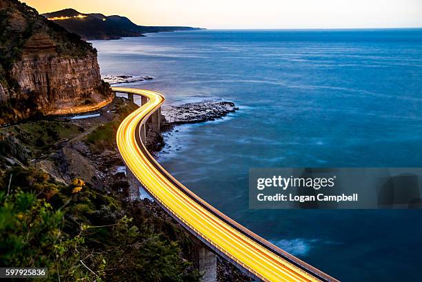 sea cliff bridge light trails traffic - illuminated bridge stock pictures, royalty-free photos & images