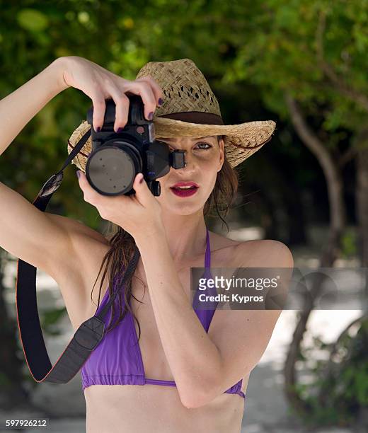 asia, maldives, young caucasian woman wearing bikini on tropical beach - sombrero de fiesta fotografías e imágenes de stock