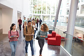 Students walk and talk using mobile devices in university