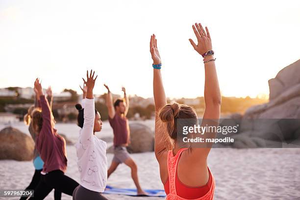 beach yoga is a full mind, body and soul experience - yoga retreat stock pictures, royalty-free photos & images