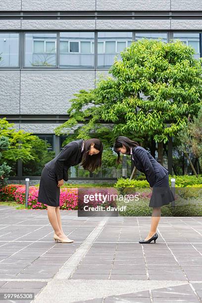 traditional formal greeting between corporate professional japanese business women - woman bowing stock pictures, royalty-free photos & images