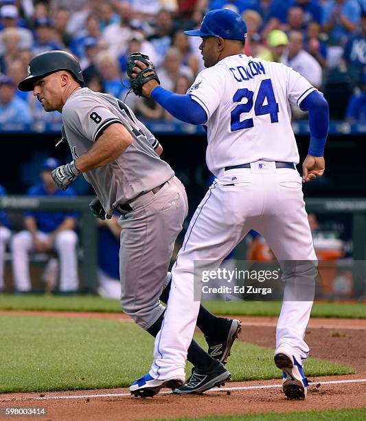 Brett Gardner of the New York Yankees is tagged out by Christian Colon of the Kansas City Royals as he is caught in a run down as he tries to score...