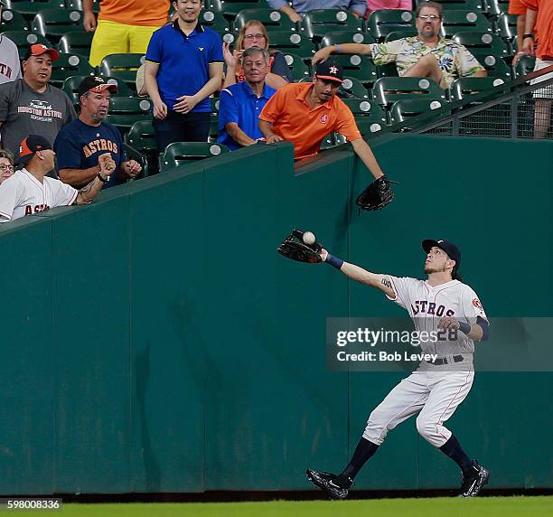 Colby Rasmus of the Houston Astros makes a catch in foul territory on a pop fly by Stephen Vogt of the Oakland Athletics in the sixth inning at...
