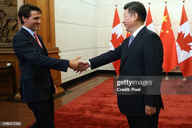 Chinese President Xi Jinping shakes hands with Canadian Premier Justin Trudeau ahead of their meeting at the Diaoyutai State Guesthouse in Beijing,...