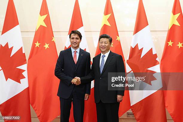 Chinese President Xi Jinping shakes hands with Canadian Premier Justin Trudeau ahead of their meeting at the Diaoyutai State Guesthouse in Beijing,...