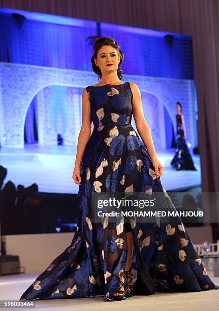 Model displays a dress created by Omani designer Sahar al-Aufi during the Omani Women's Fashion Trends event, in the Omani capital Muscat, on August...