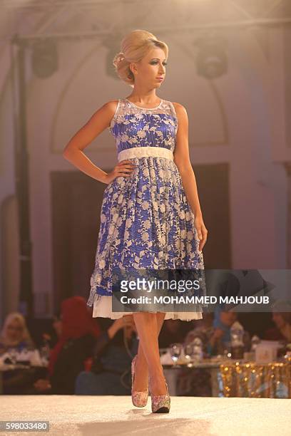 Model displays a dress created by Omani designer Sahar al-Aufi during the Omani Women's Fashion Trends event, in the Omani capital Muscat, on August...