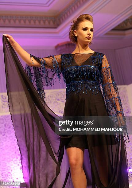 Model displays a dress created by Omani designer Sahar al-Aufi during the Omani Women's Fashion Trends event, in the Omani capital Muscat, on August...